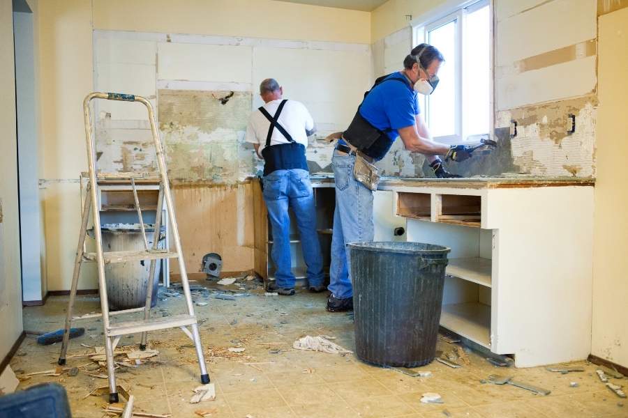 Two workers renovating a kitchen during a home renovation project