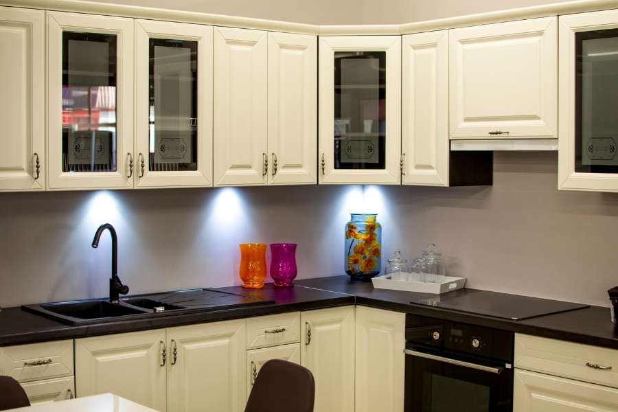 Elegant white kitchen cabinets with decorative handles and glass panels showcasing kitchen cabinet hardware.