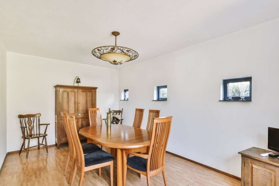 Traditional dining room featuring an ornate hanging fixture and wooden furniture.